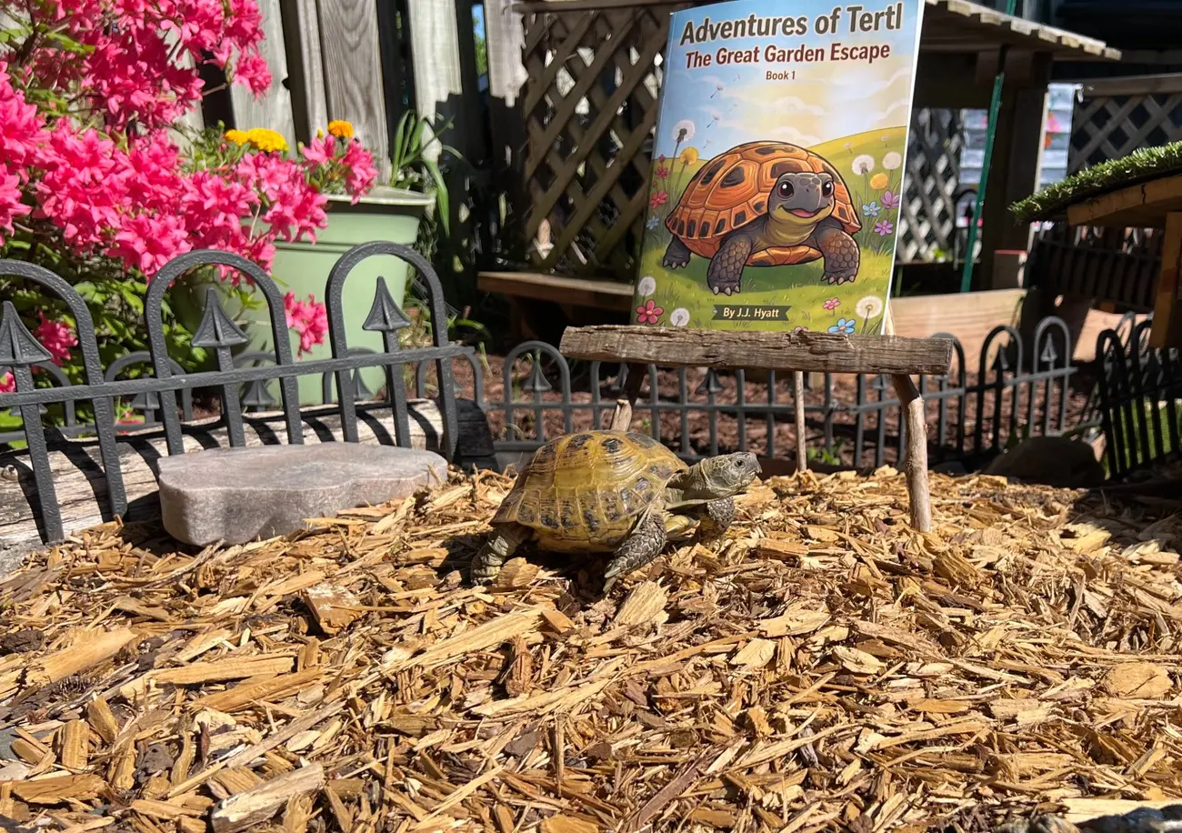The real Tertl walking through her garden kingdom, with a copy of The Great Garden Escape propped on a little wooden easel behind her